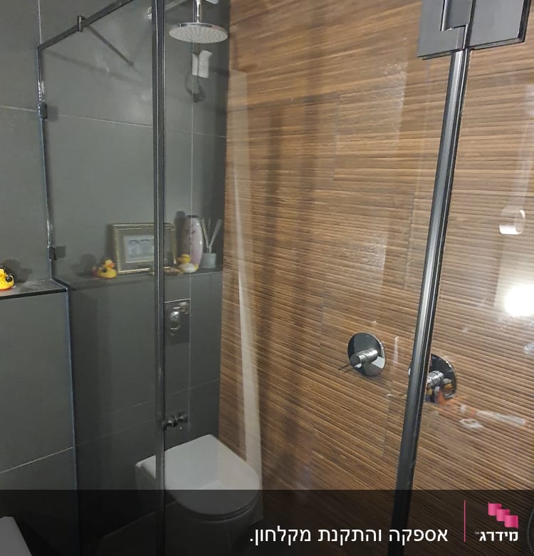 מקלחת עם דלת זכוכית וראש מקלחת עגול